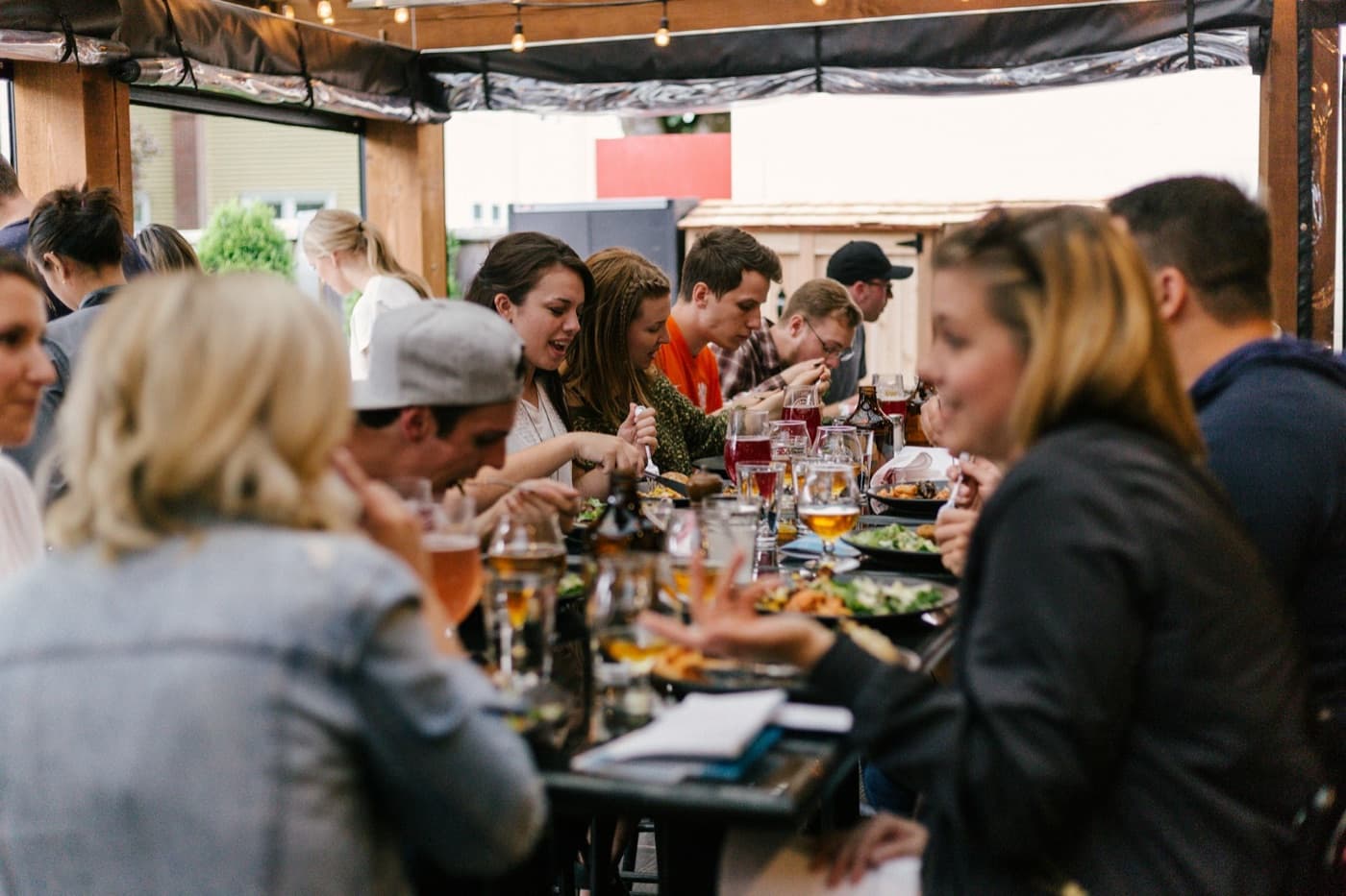 Friends eating together at a long restaurant table